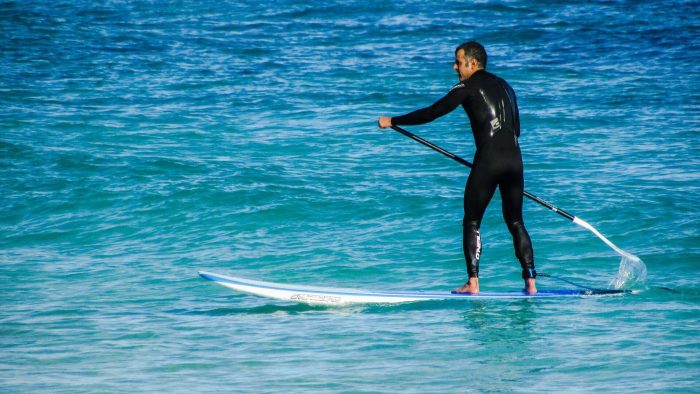 Man in a wetsuit paddleboarding