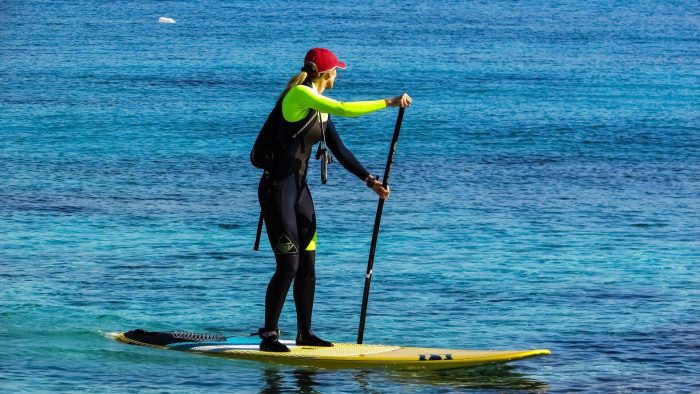 Woman in a wetsuit paddleboarding